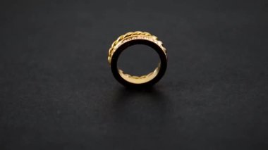 Dönen altın düğümlü parlak ikiz altın yüzük ve siyah arka planda zirkon. Sevgililer günü hediyesi kadar güzel..