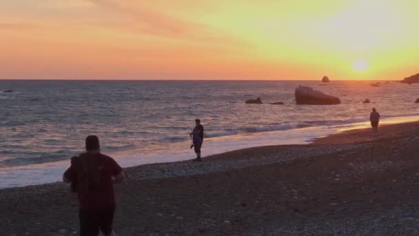 人々は自分自身を楽しみ キプロスのパフォスでペトラ ロミウ周辺のビーチで日没の写真を撮る アフロディーテのギリシャ神話発祥の地と考えられている — ストック動画