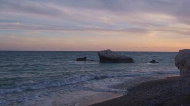 Beach çevresinde Petra tou Romiou, Paphos, Kıbrıs için güzel gün batımı manzarası. Yunan mitolojisinde Afrodit'ın Doğum yeri olarak kabul edilir.