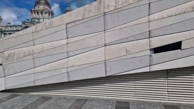 The Three Graces buildings at the Liverpool waterfront revealed behind the marble stairs to the LIverpool Museum at the Liverpool Docks on a beautiful spring day