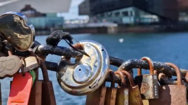 Modern and classic architecture is revealed behind love padlocks at the Liverpool Docks, Port of Liverpool on a beautiful spring day