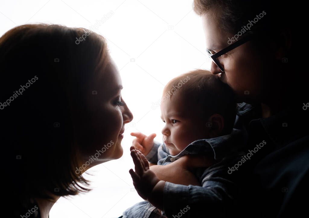 Silhouette of young family dad mom son