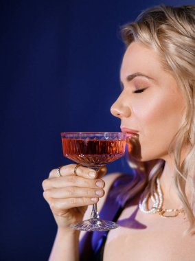 Close-up portrait of a blonde girl with a glass
