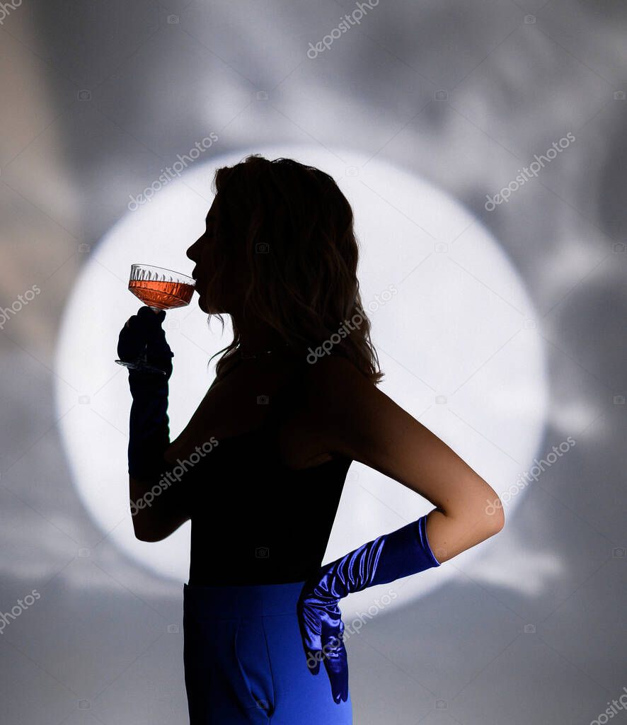 Silhouette of a girl drinking champagne