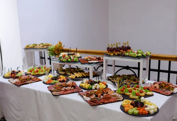 Mesa com canapés e fatias de carne e queijo — Fotografia de Stock