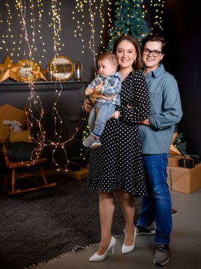 Genç aile babası, anne oğlu Noel ağacı dekorunda çocuk.