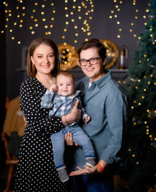 Genç aile babası, anne oğlu Noel ağacı dekorunda çocuk.