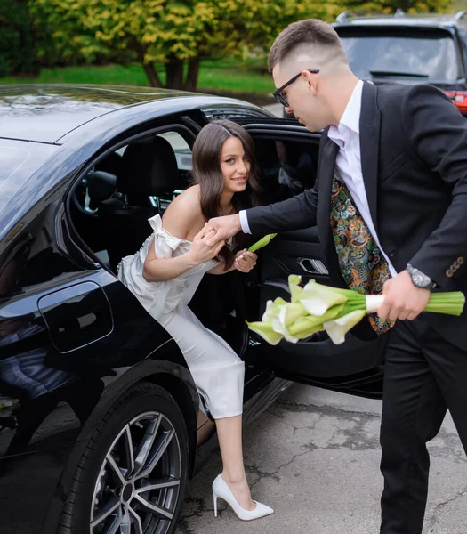 Beautiful bride with black hair gets out of the car — Stok Foto