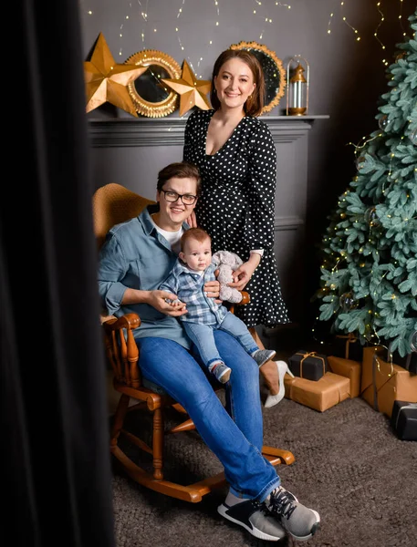 Genç aile babası, anne oğlu Noel ağacı dekorunda çocuk.