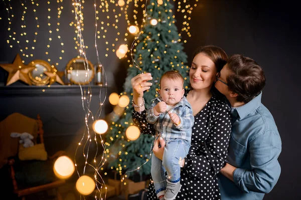 Genç aile babası, anne oğlu Noel ağacı dekorunda çocuk.