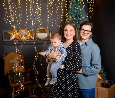 Genç aile babası, anne oğlu Noel ağacı dekorunda çocuk.