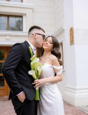 Beautiful young newlywed couple in sunglasses walking 