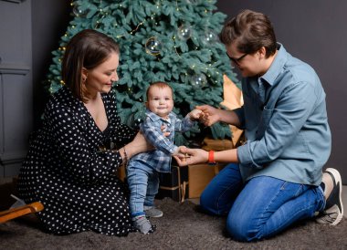 Genç aile babası, anne oğlu Noel ağacı dekorunda çocuk.