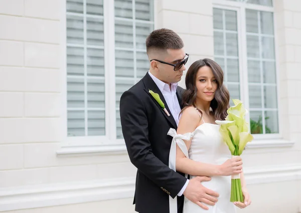 Beautiful young newlywed couple in sunglasses walking — Stok Foto