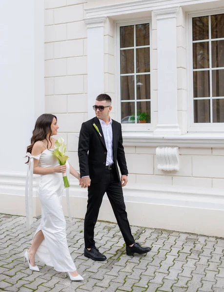 Bela jovem casal recém-casado em óculos de sol andando — Fotografia de Stock