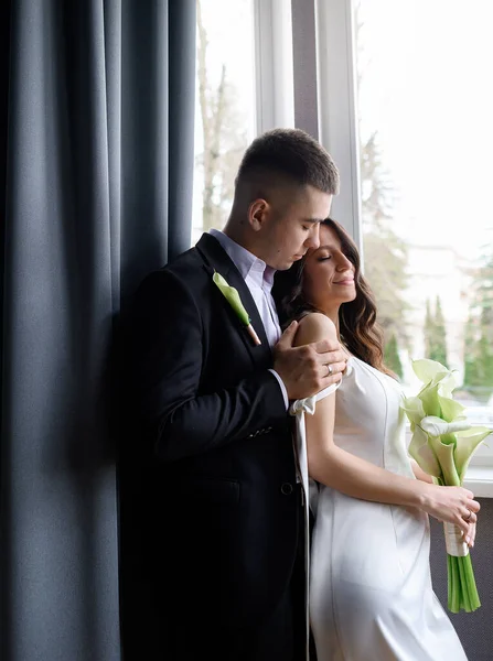 Красива пара наречених позує на фоні вікна — стокове фото