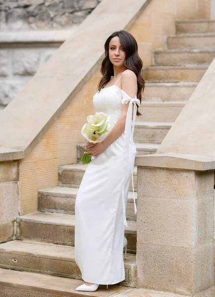 Beautiful young bride posing on a background of vintage stairs — Stok fotoğraf