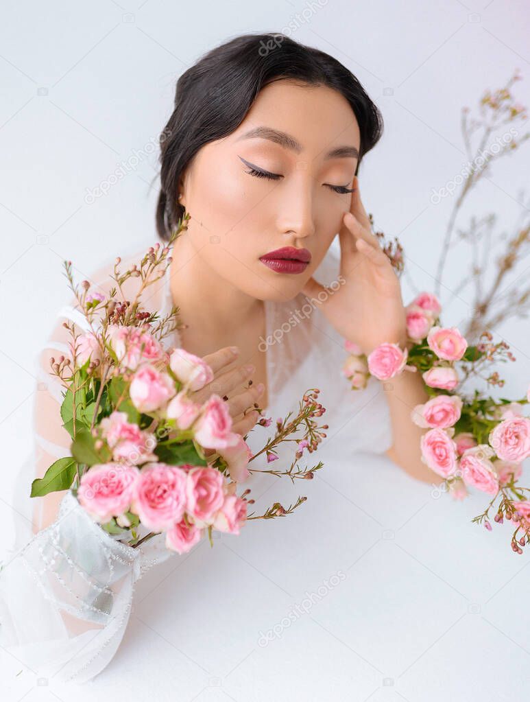 Beautiful asian with flowers on a white background close up