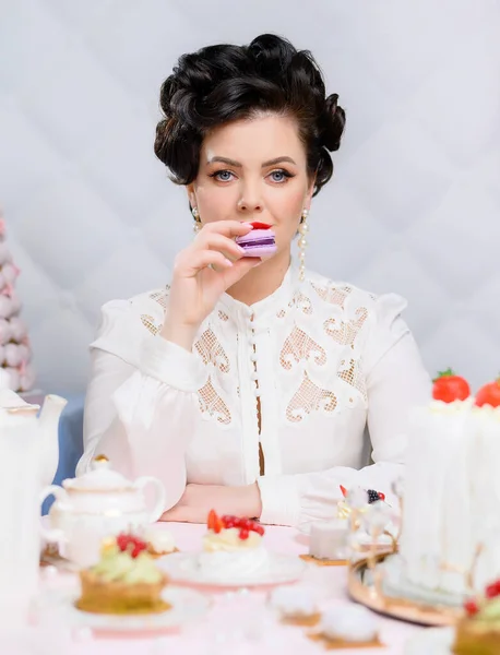 Beautiful brunette woman tastes cake — Fotografia de Stock