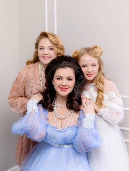 Güzel anne sarılır ve iki sarışın kızıyla poz verir.