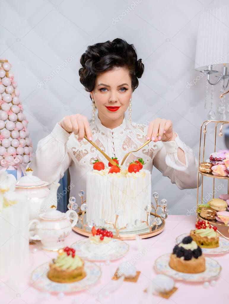 Beautiful brunette woman cuts a beautiful big white cake 