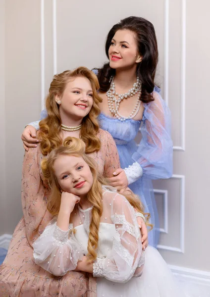 Güzel anne sarılır ve iki sarışın kızıyla poz verir.