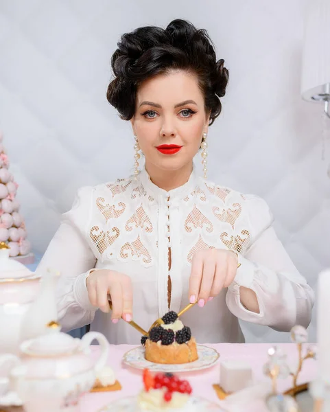 Beautiful brunette woman cuts a beautiful little cake — Fotografia de Stock