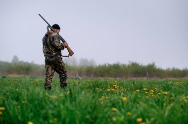 Omzunda silahla yürüyen bir erkek avcısı. 