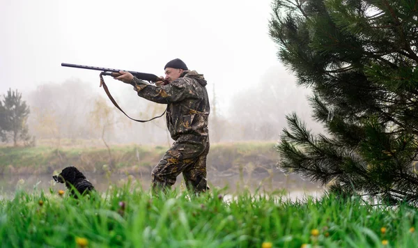 Jäger zielt mit Gewehr auf nebligen See — Stockfoto