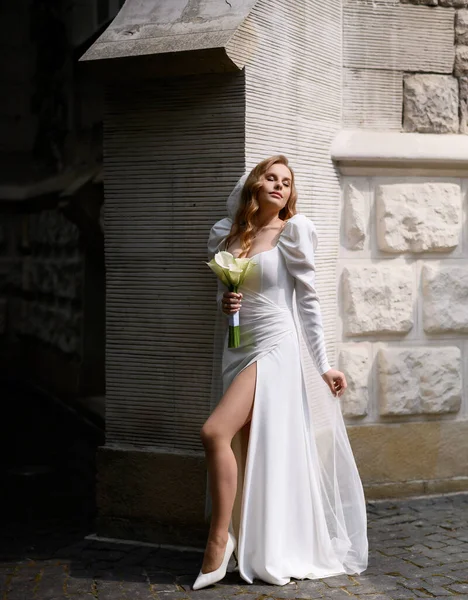 Красивая блондинка-невеста в белом платье с позой щели — стоковое фото