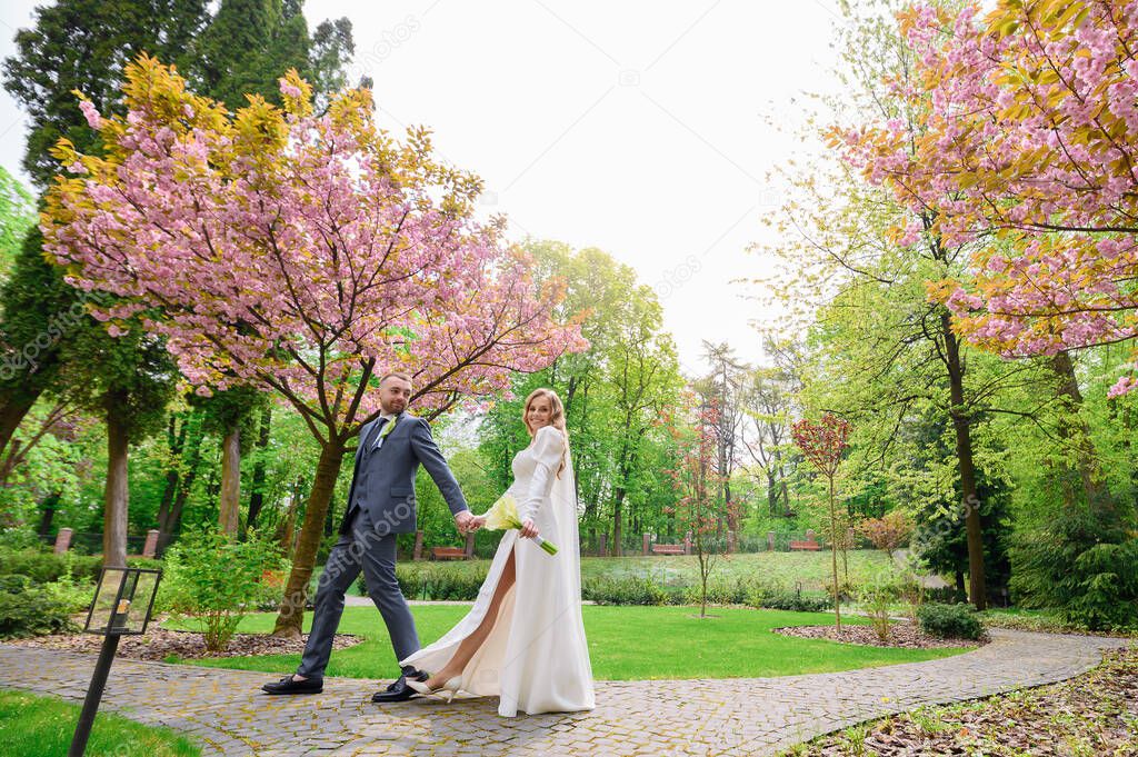 Beautiful wedding couple caucasian walking holding hands 