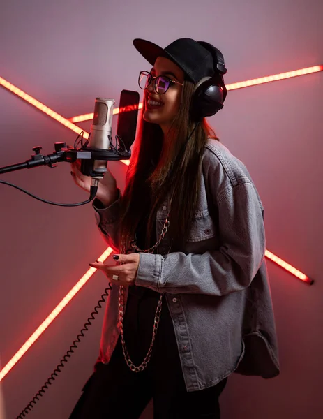 Menina elegante bonita cantando em um microfone em um estúdio de gravação — Fotografia de Stock