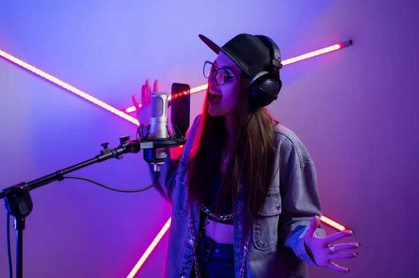 Menina elegante bonita cantando em um microfone em um estúdio de gravação — Fotografia de Stock