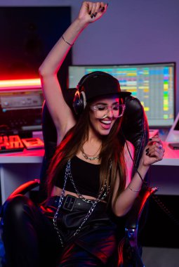 Beautiful caucasian girl in stylish clothes works in a recording studio 