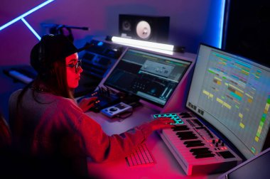 Beautiful caucasian girl in stylish clothes works in a recording studio