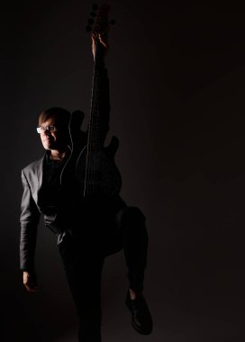 Bas gitarlı, gözlüklü beyaz adam. 