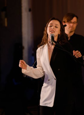 Orkestra ve orkestranın arka planında genç ve güzel bir vokalist.