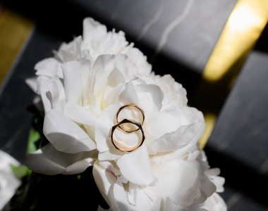 Bir buket beyaz şakayıklı alyanslar güneşli merdivenlerde yatıyor. Kapat.