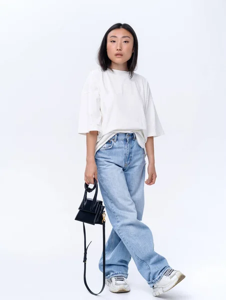 Beautiful Asian Girl White Shirt Blue Jeans Poses White Wall — Stok fotoğraf