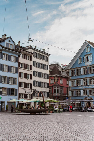 Zurich Switzerland. 5. July 2018 Mnsterhof, square next to Fraumunster church with cobbled pavement, colorful buildings and modern fountain.