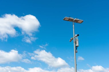 Mavi gökyüzü arka planlı mobese kamerası. Sokak direğindeki güvenlik kameralarının yakın çekimleri sokaktaki güvenliği sağlıyor..