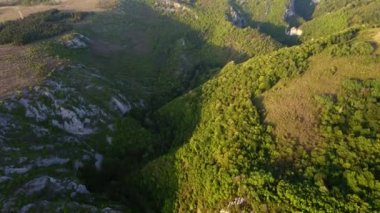 Aerial view of karst landscape, in Romania, with valleys and cliffs, at sunset