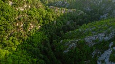 Aerial view of karst landscape, in Romania, with valleys and cliffs, at sunset