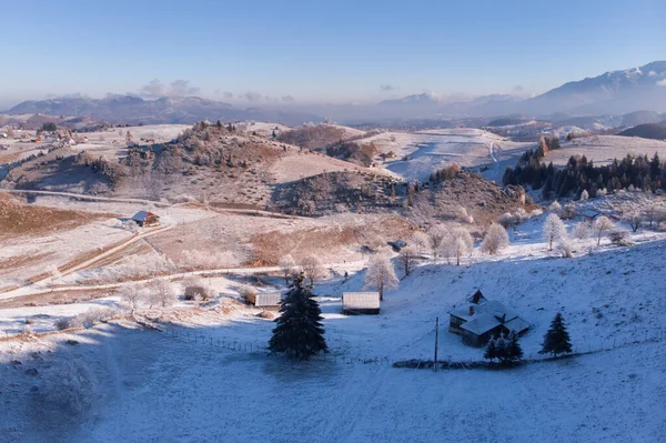 Güzel Transilvanya köyü Pestera 'nın kışın buzlu manzarası, beyaz don, taze kar, kar ve sis ile, Karpatya dağlarının eteklerinde.