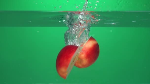 Långsam Rörelse Ett Äpple Faller Medan Rotera Vattnet Och Delas — Stockvideo