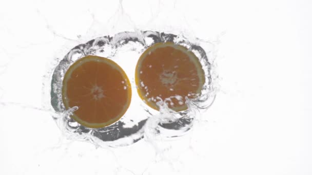Langsame Szene Von Zwei Orangenhälften Die Ins Wasser Fallen Gefilmt — Stockvideo