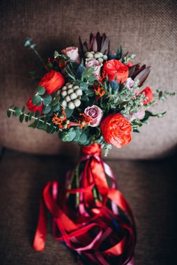 Bir buket kırmızı ve beyaz gül, yeşil okaliptüs yaprakları. Düğün, tatil. Gelin ve damat.