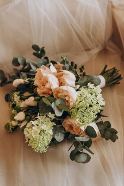 Beyaz, krema, yeşil güller, şakayıklar, Eustomalar ve yeşil okaliptüs yaprakları, beyaz orkide çiçekleri..