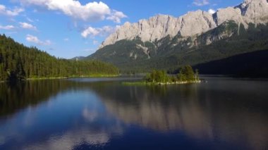 Zugspitze zirvesinin altındaki Eibsee Dağı 'nın küçük adalı havadan çekilmiş görüntüleri. Almanya 'nın en güzel buzul gölü. Bavyera Alpleri' ndeki temiz zümrüt yeşili su. Orta Avrupa.