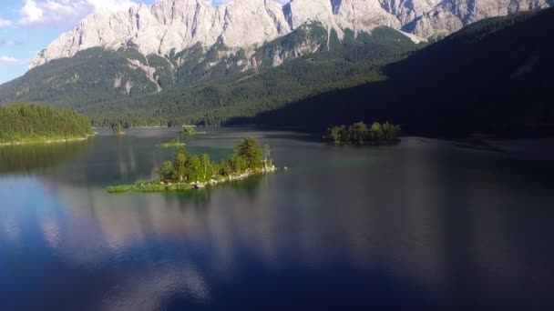 小さな島でZugspitzeピークの下の山の湖Eibseeの空中映像 バイエルンアルプスの澄んだエメラルドグリーンの水でドイツで最も美しい氷河湖 中央ヨーロッパ — ストック動画